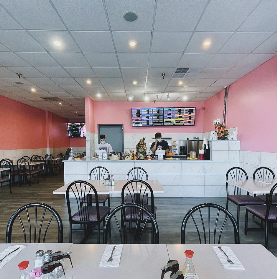 Inside of a Chinese restaurant with white tables and black chairs